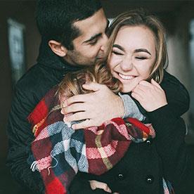 couple cuddling, smiling.